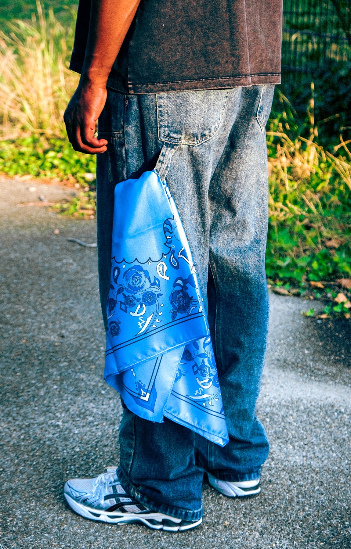 Hand houdt de blauwe paisley bandana vast